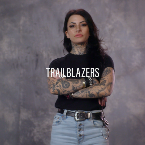 Person with crossed arms standing confidently in a studio with the word ‘Trailblazers’ overlaid.