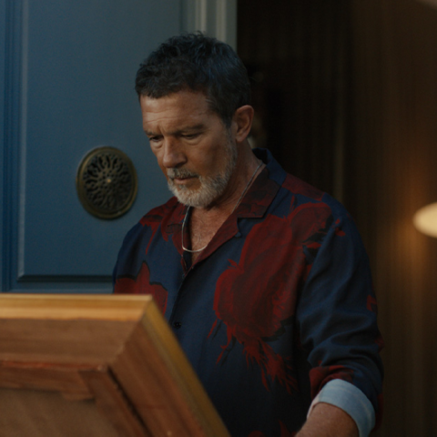 Antonio Banderas examining a framed painting at a doorway as part of the Goya campaign advertisement.