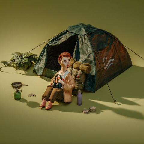 Claymation woman reclining in a chair surrounded by potted plants on a warm yellow background.