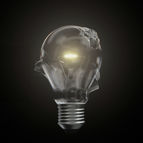 Cracked glass lightbulb with a glowing filament against a dark background, symbolising innovation and breakthrough ideas.
