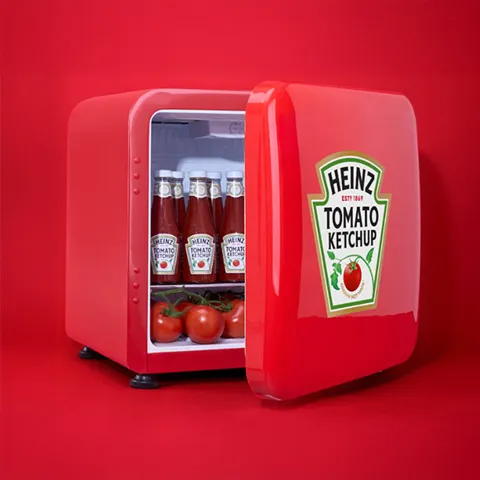 A mini fridge containing multiple bottles of Heinz ketchup.