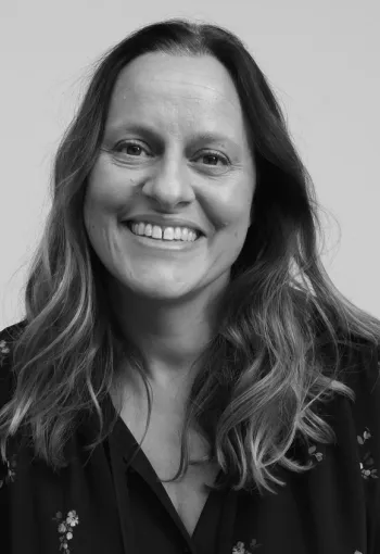 Natasha Wellesley looking head on at the camera in a black and white headshot.