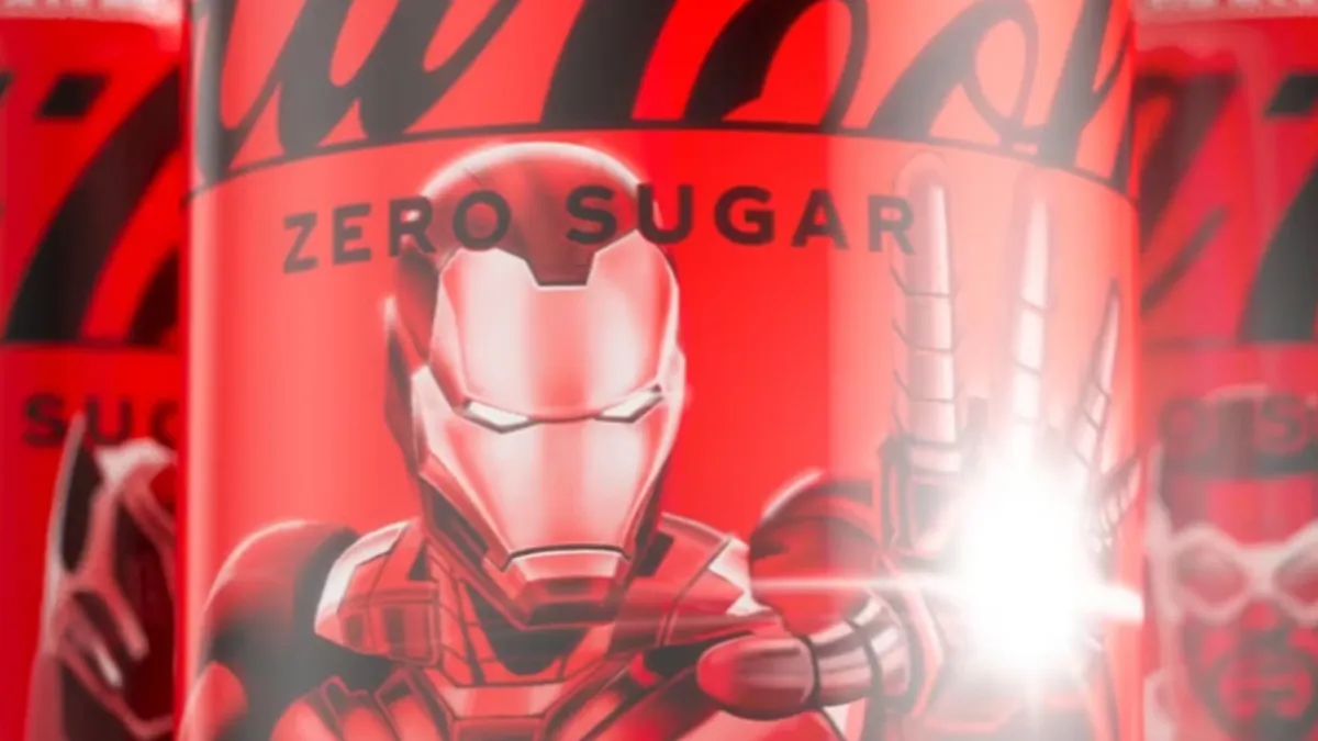 Close-up of a red Coca-Cola Zero Sugar can featuring a stylised armoured superhero illustration with a glowing hand effect.